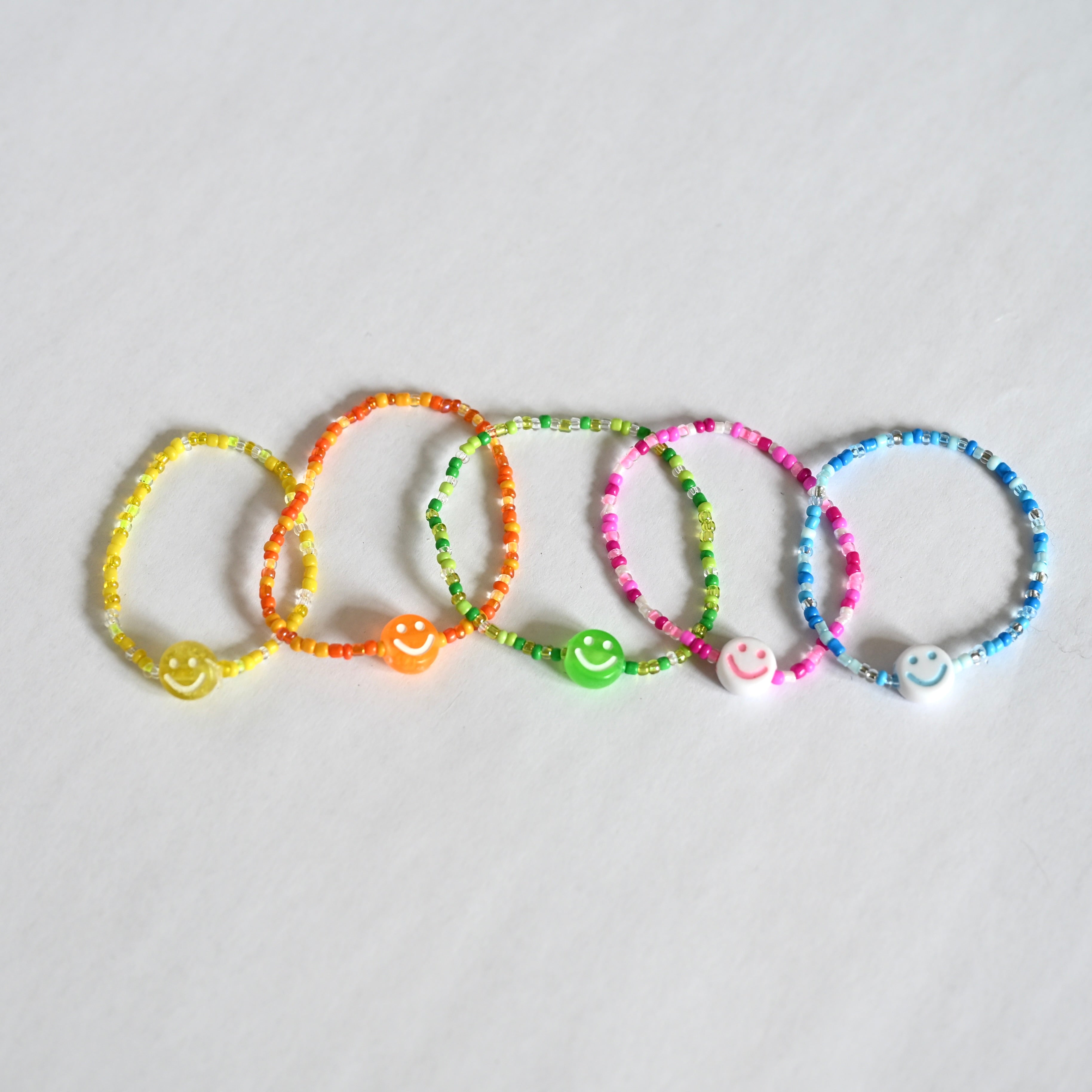 Elastische Perlenarmbänder in Kindergrösse, in den Farben gelb, orange, grün, pink, blau.